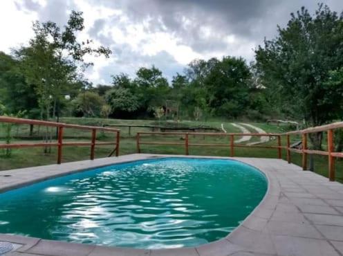una pequeña piscina con una valla de madera en Raíces de la Estancia en San Luis