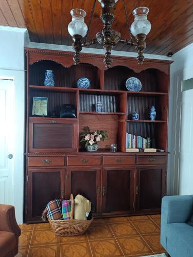 a large wooden cabinet with a basket in a room at Casa da Atalaia in Angra do Heroísmo