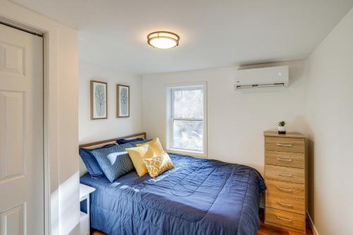 een slaapkamer met een blauw bed en een raam bij Saugerties Cabin Rental with Fire Pit and Creek Access in Saugerties