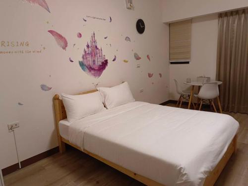 a bedroom with a white bed and a table at 星之芳庭 潮州民宿 親子寵物友善 in Chaozhou