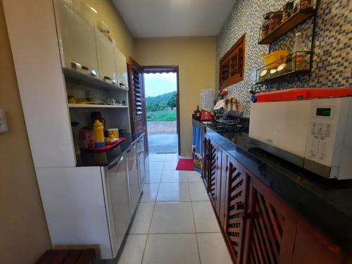 a kitchen with white cabinets and a counter top at Chalé na Serra in Mulungu