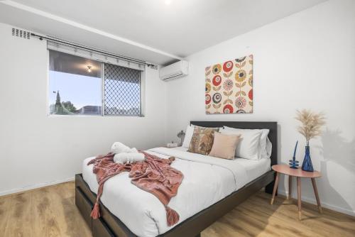 Un dormitorio con una cama grande y una ventana en EAST4 - Vintage Vibes East Freo 2B 1BA, en Fremantle