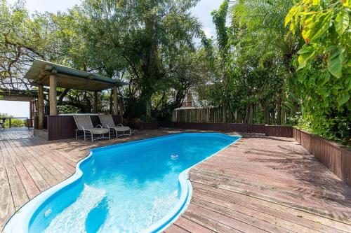 una piscina en un patio con terraza de madera en Apto pé na areia com vista p/ mar JBM, en Florianópolis