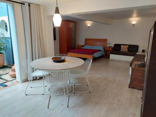 1 dormitorio y sala de estar con mesa y sillas. en Espaço acolhedor com transporte público de fácil acesso, en São Paulo