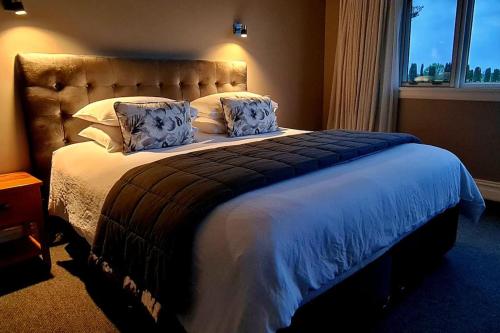 um quarto com uma cama grande e uma janela grande em Okauia House, Matamata em Matamata