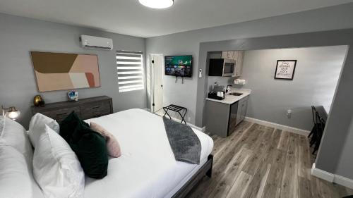 a bedroom with a white bed and a desk at Oceano Suites Daytona Beach in Daytona Beach