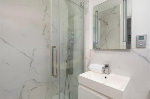 La salle de bains blanche est pourvue d'un lavabo et d'une douche. dans l'établissement Lux 2-Bed, Central, Balcony, Free Secure Parking, à Reading