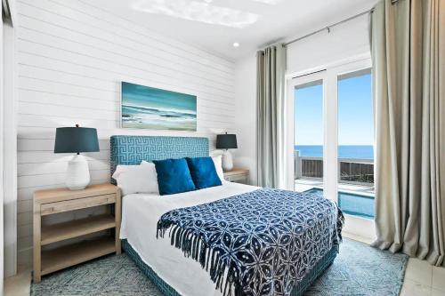 a bedroom with a bed and a view of the ocean at Laguna Loafin' - Panama City Beach, FL in Panama City Beach