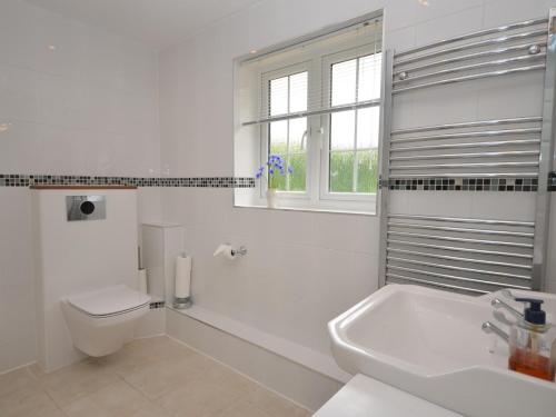 a white bathroom with a toilet and a sink at 1 Bed in Taunton 75135 in Isle Brewers