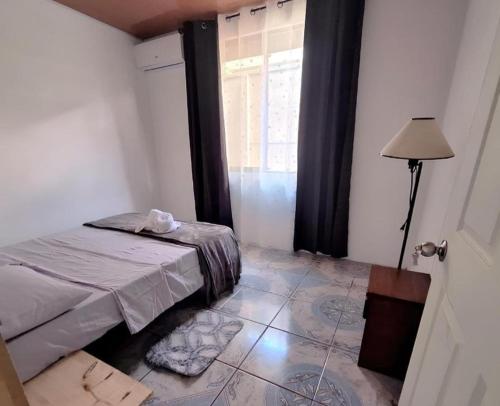 ein kleines Schlafzimmer mit einem Bett und einem Fenster in der Unterkunft Il Padrino Corcovado Apartament in Puerto Jiménez