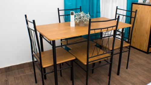 a wooden table with four chairs around it at Salamanca Loft in Los Güichiches