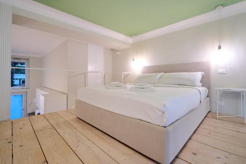 MILAN design Loft-Hosted by Sweetstay في ميلانو: غرفة نوم بيضاء مع سرير كبير مع شراشف بيضاء