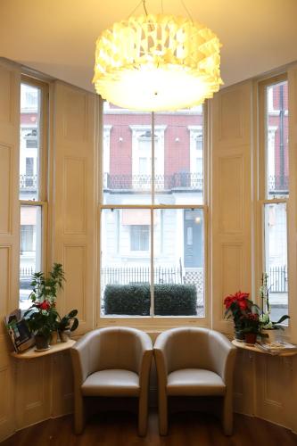 a room with two chairs and a large window at Dreamtel London Kensington in London