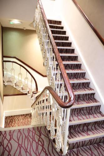 a staircase in a home with white and brown carpet at Dreamtel London Kensington in London