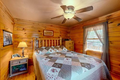 a bedroom with a bed and a ceiling fan at Pine Tree Lodge in Sautee Nacoochee