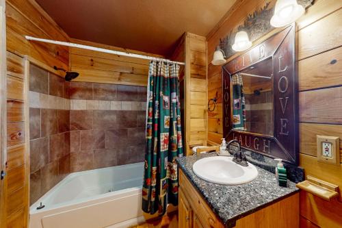 a bathroom with a sink and a bath tub and a sink at Pine Tree Lodge in Sautee Nacoochee