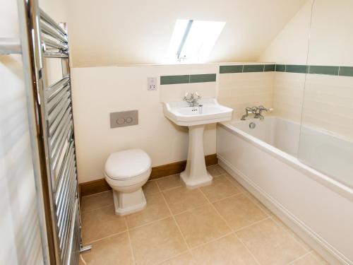 a bathroom with a toilet and a sink and a tub at 3 Bed in Melbury Abbas 48804 in Melbury Abbas