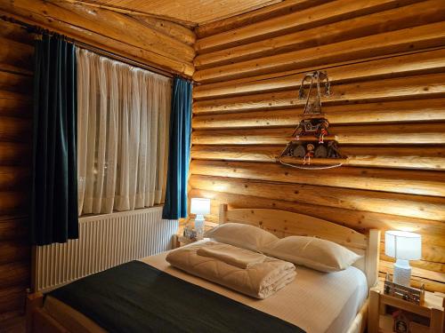 a bedroom with a wooden wall with a bed at Cabana Alesia, relaxare la poalele Raraului in Câmpulung Moldovenesc