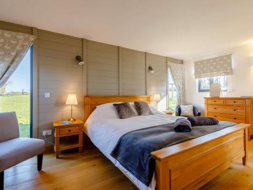 1 dormitorio con 1 cama grande y 1 silla en 3 Bed in Ashreigney 65742 en Ashreigney