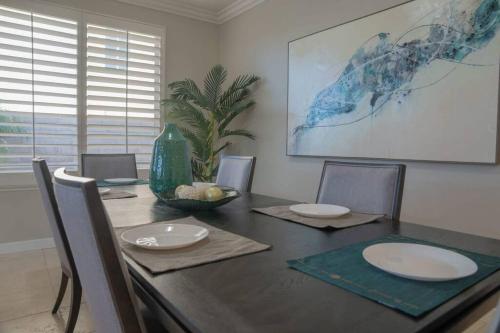 a dining room with a table with plates and chairs at Ping Pong, A/C, Netflix, Grill, Jacuzzi Tub, W/D in Placentia