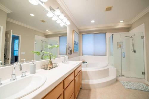a bathroom with two sinks and a shower and a tub at Ping Pong, A/C, Netflix, Grill, Jacuzzi Tub, W/D in Placentia