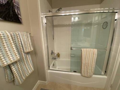 a bathroom with a shower with a glass door at Ping Pong, A/C, Netflix, Grill, Jacuzzi Tub, W/D in Placentia