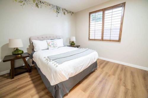 a white bedroom with a bed and a window at Ping Pong, A/C, Netflix, Grill, Jacuzzi Tub, W/D in Placentia