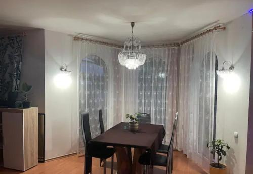 comedor con mesa, sillas y lámpara de araña en Soukroma ložnice s terasou a pracovnou, en Praga