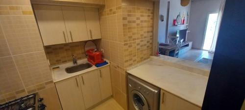 a kitchen with a sink and a washing machine at A Residence - Superior One Bedroom Aparthotel in Sharm El Sheikh