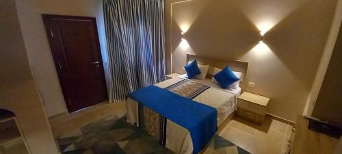 a small bedroom with a bed with blue pillows at A Residence - Superior One Bedroom Aparthotel in Sharm El Sheikh