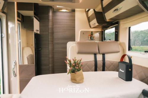 a table in an rv with a vase of flowers on it at Live On The Horizon 1 in Ribadesella