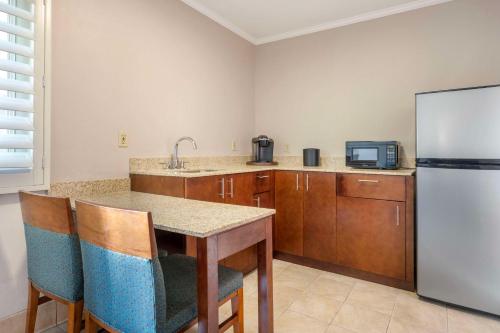 a kitchen with a refrigerator and a table with chairs at Best Western Plus Beach View Lodge Carlsbad in Carlsbad
