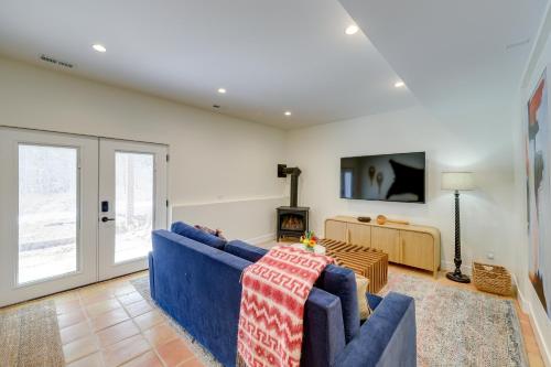 a living room with a blue couch and a fireplace at Spacious Black Hawk Home with Deck and Mountain Views! in Black Hawk
