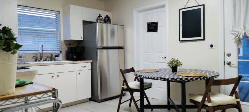 a kitchen with a table and a refrigerator at House Close to Downtown, Airport, Raymond James Stadium, and Many More Places in Tampa
