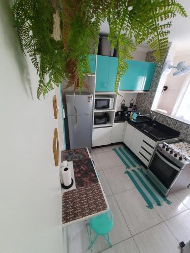eine Küche mit blauen und weißen Schränken und einem Tisch in der Unterkunft Bertioga Praia do SESC - Apartamento de 2 quartos in Bertioga