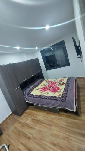 um quarto com uma cama num quarto com uma televisão em Résidence safoua em Bir el Djir