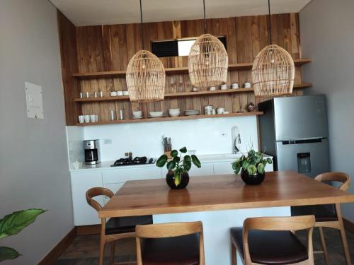 a kitchen with a wooden table with chairs and a refrigerator at Montecielo Hosting in Guatapé