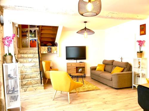 a living room with a couch and a tv at Caporizon-Rug'BnB Gîte-Brantôme-6 personnes in Biras