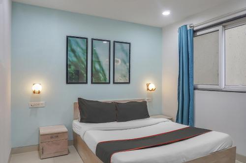 uma cama num quarto com três fotografias na parede em Collection O 83129 Hotel Galaxy Hospitality em Kharadi