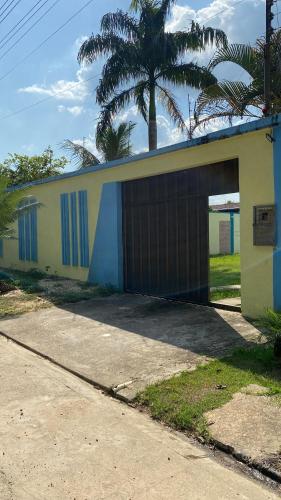 un edificio con un garaje con una palmera detrás de él en Casa Residencial Tarumã en Manaos