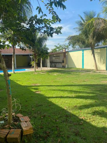 a park with a building and a tree in the grass at Casa Residencial Tarumã in Manaus