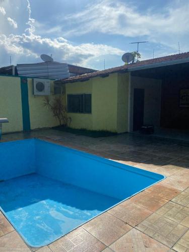 a blue swimming pool in front of a house at Casa Residencial Tarumã in Manaus
