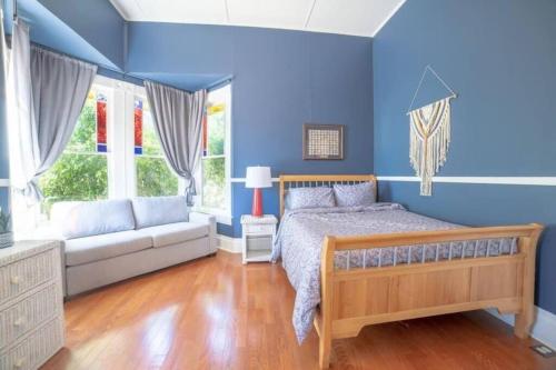 a blue bedroom with a bed and a couch at Sea View, Sauna, Gym, Bikes, W/D, Netflix in Ventura