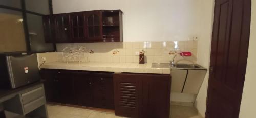 a kitchen with brown cabinets and a white counter top at Reverie Hill Bungalow, Kandy in Kandy