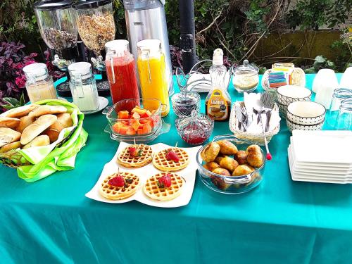 a table topped with plates of food and bowls of fruit at Casa Baraquel in Arequipa