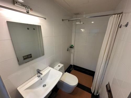 W łazience znajduje się umywalka, toaleta i lustro. w obiekcie Alia Express Hotel Twelve a12 Kuantan w mieście Kuantan