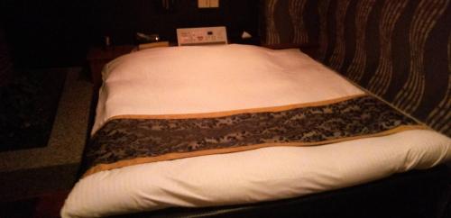 a pair of twin beds in a room at ホテル ココアミルク in Nishi-hōjubana