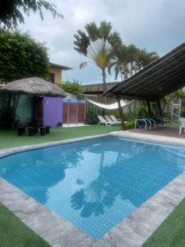 a large swimming pool in a yard with a house at La casa de naty by Ecuapolsky in Tonsupa