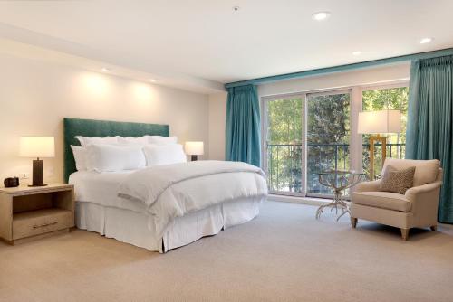 a bedroom with a large bed and a chair and windows at The Galatyn Lodge in Vail