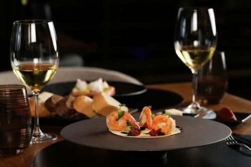 a table with two glasses of wine and a plate of food at Tunis Marriott Hotel in Tunis